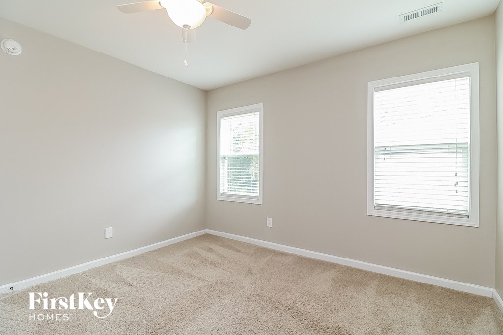 a bedroom with a carpeted floor and a ceiling fan