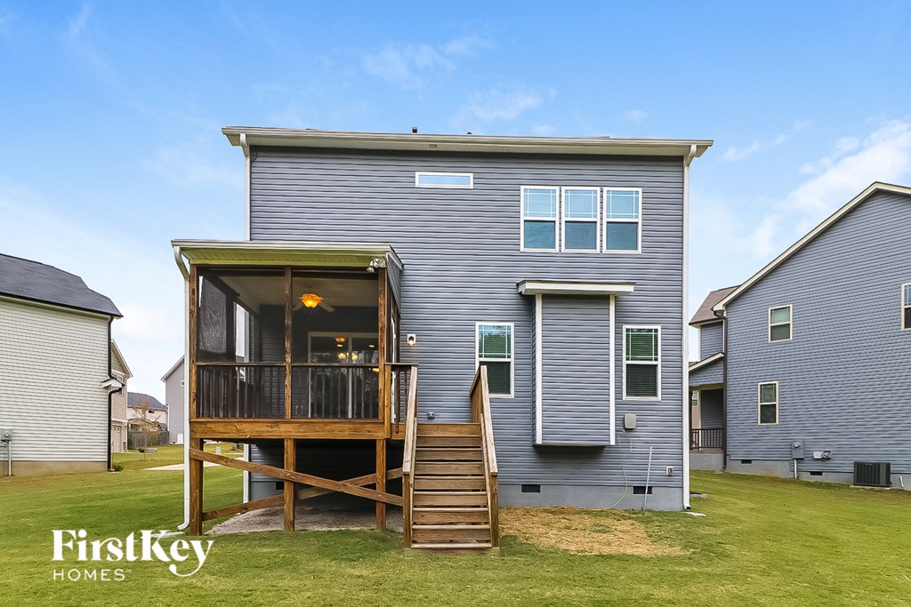 the back of a blue house with a deck and stairs