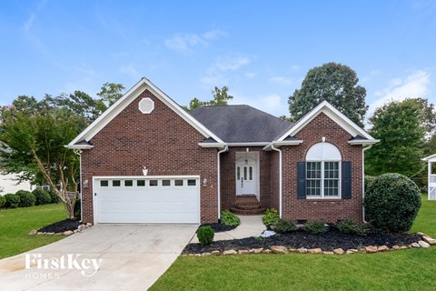 a brick house with a white garage door and a lawn
