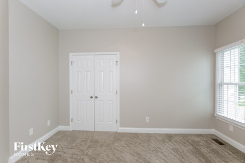 a bedroom with a white door and a carpeted floor