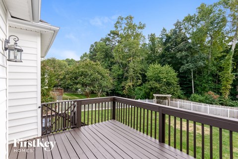 a deck with a view of a yard and trees