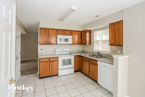 A kitchen with wooden cabinets and white appliances.