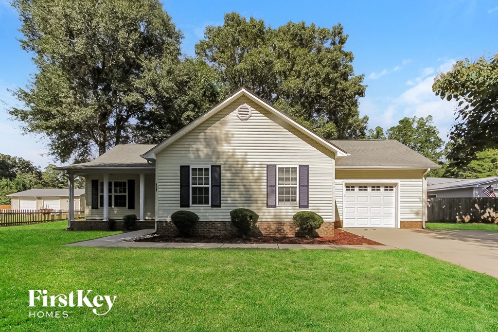 a white house with a lawn and a driveway