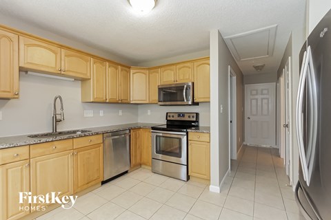 a kitchen with wooden cabinets and stainless steel appliances