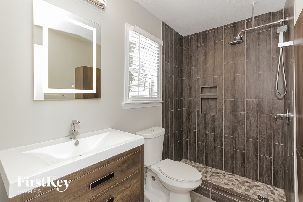 a bathroom with a shower and a sink and a toilet