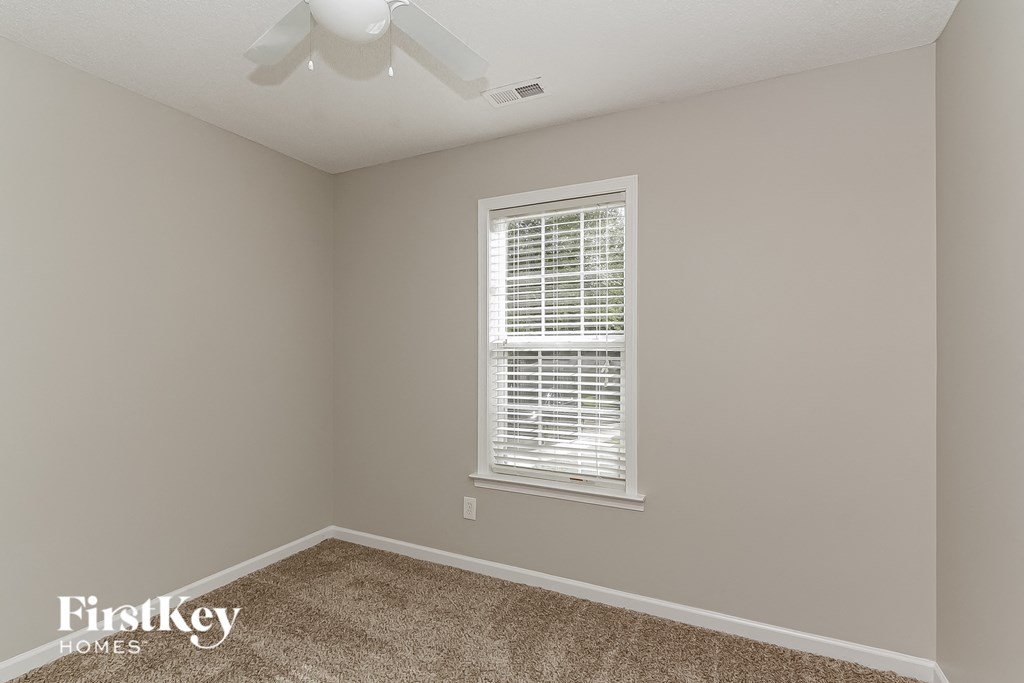 a empty room with a window and a ceiling fan