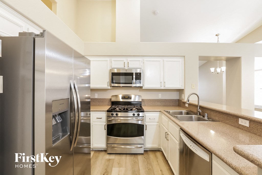 A kitchen with a stainless steel refrigerator and a stainless steel oven.