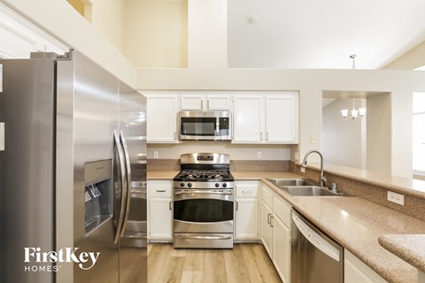A kitchen with a stainless steel refrigerator and a stainless steel oven.