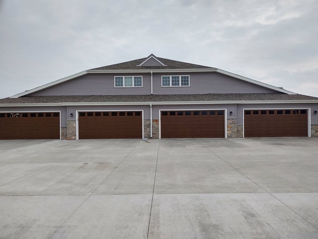 the front of a garage with two brown garage doors