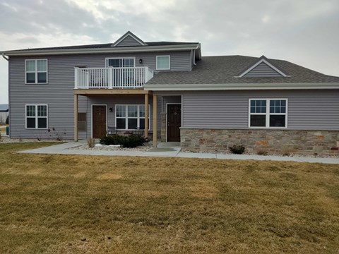 a house with a porch and a stone wall