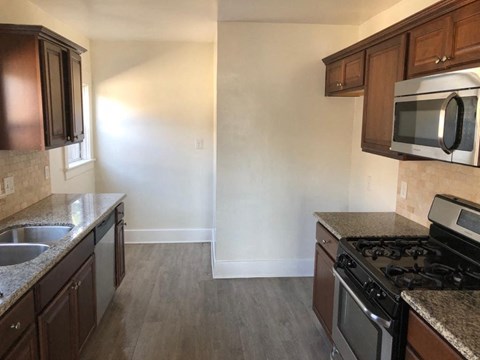 an empty kitchen with wooden cabinets and stainless steel appliances