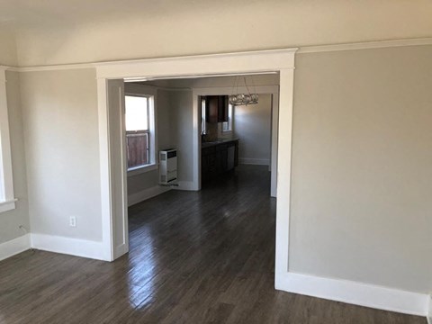an empty living room with a hard wood floor