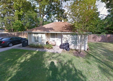 A house with a brown roof and a white fence.