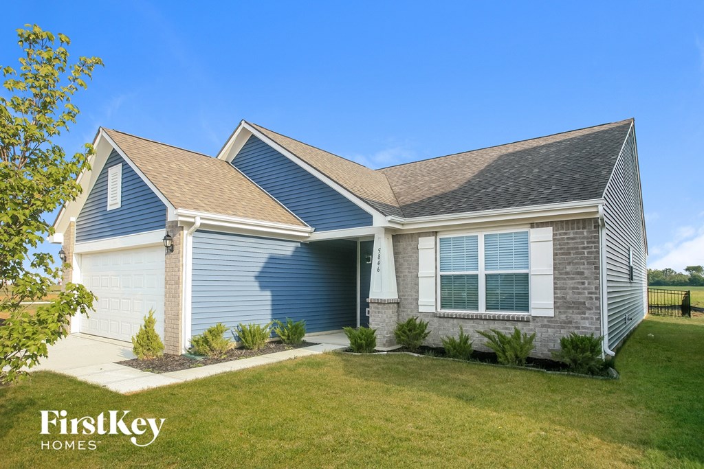 A house with a blue garage door is for sale by FirstKey Homes.