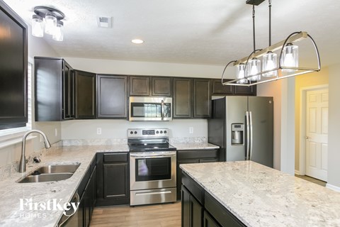 A kitchen with black cabinets and stainless steel appliances.
