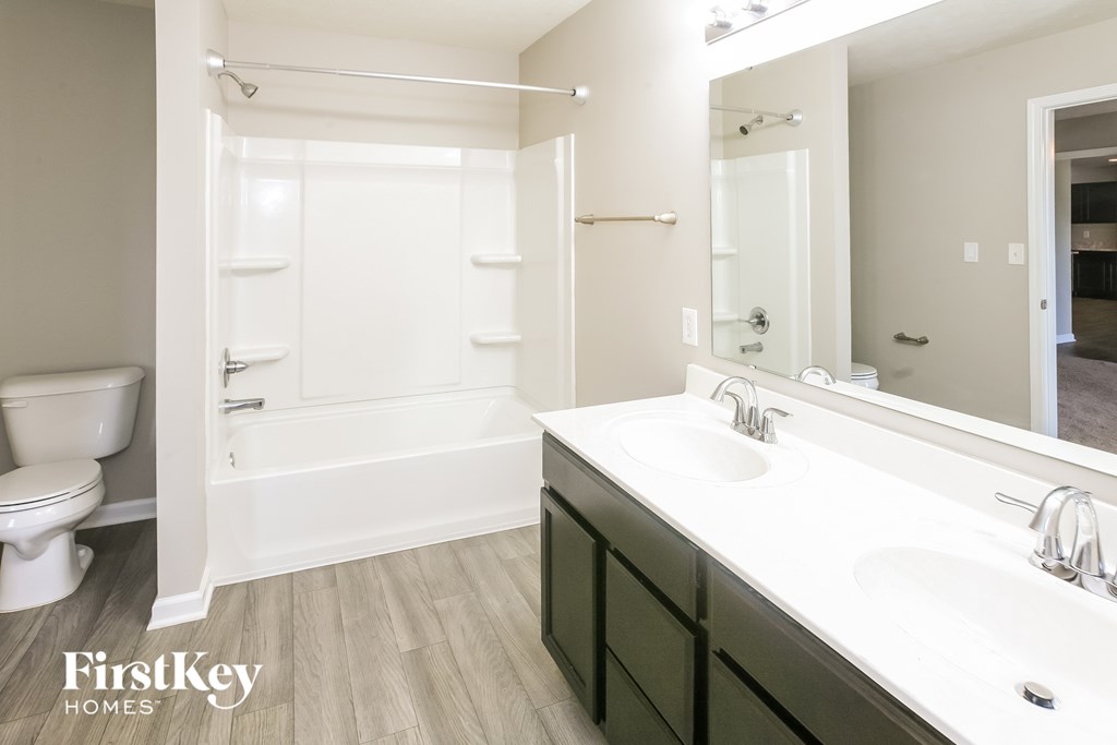 A bathroom with a white sink and a white toilet.