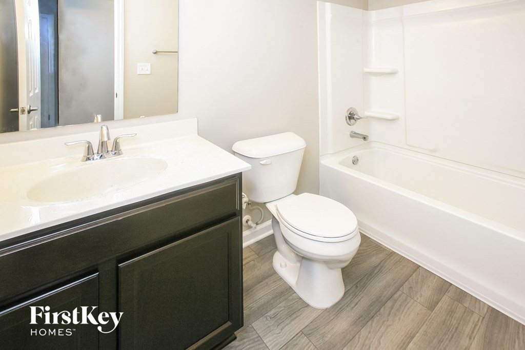 A bathroom with a toilet, sink, and bathtub.