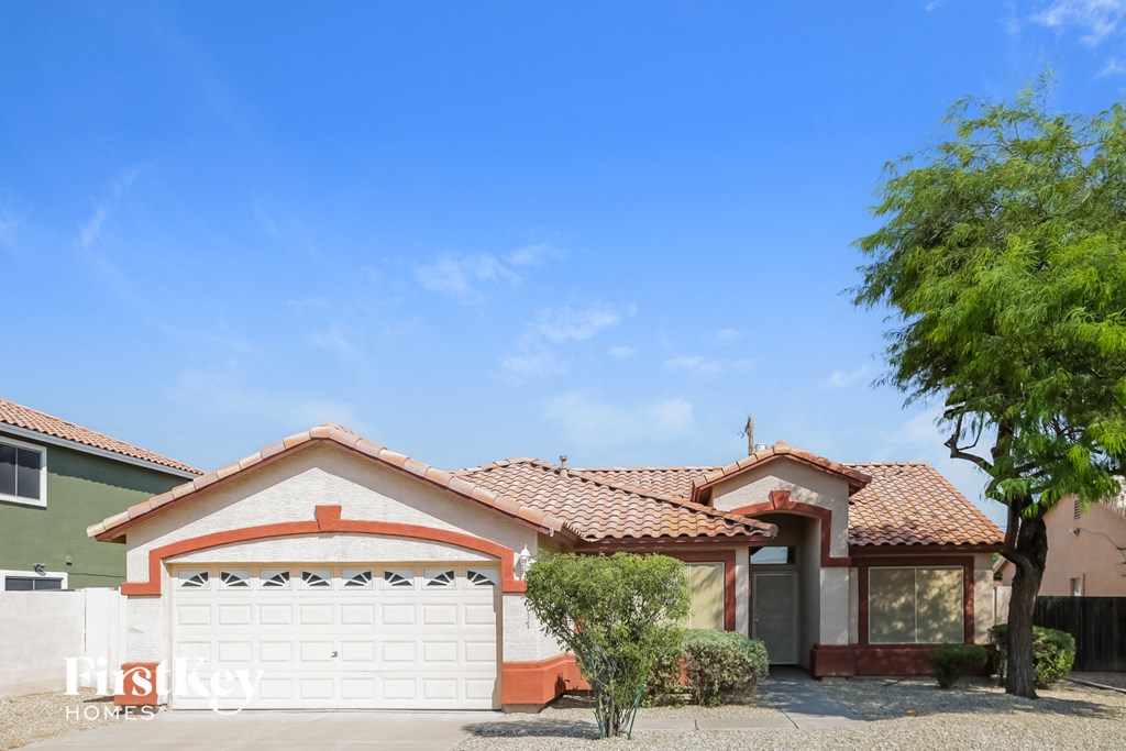 a house with a garage and a tree in front of it
