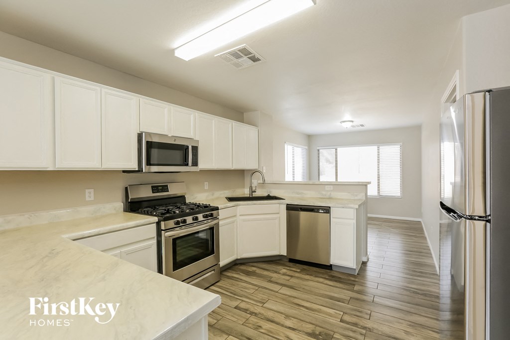 a kitchen with white cabinets and stainless steel appliances