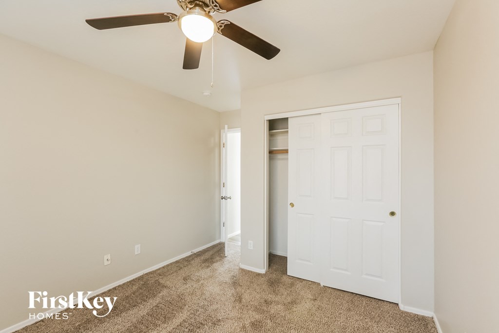 a bedroom with a ceiling fan and a closet