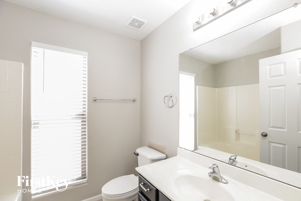 a bathroom with a large mirror and a toilet and a sink
