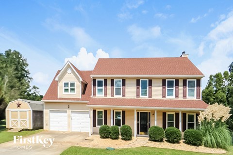 a house with a red roof and white garage doors