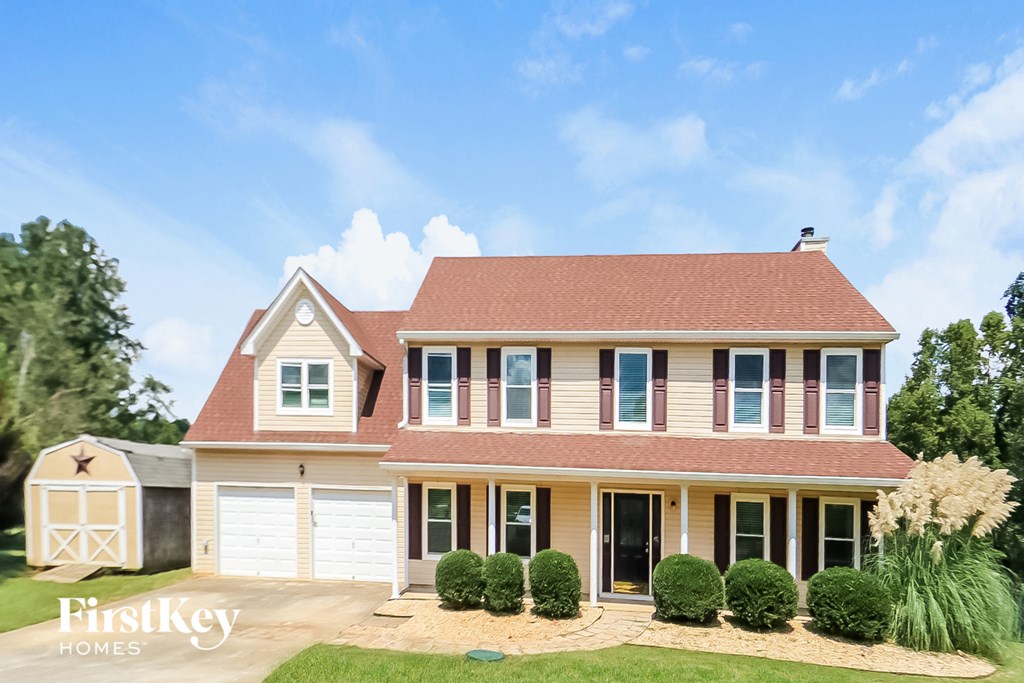 a house with a red roof and white garage doors
