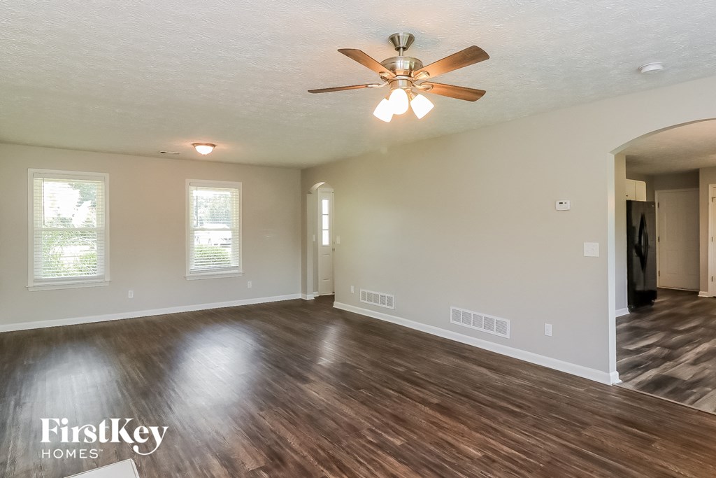 the living room of an empty house with a ceiling fan