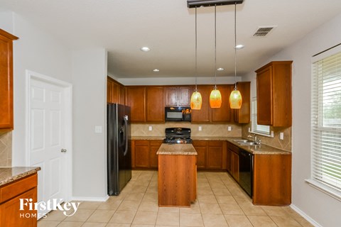 a kitchen with wood cabinets and black appliances and a counter top