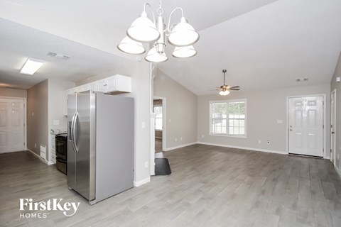 A kitchen with a refrigerator and a ceiling fan.