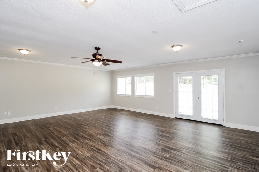 A spacious room with a ceiling fan and wooden flooring.