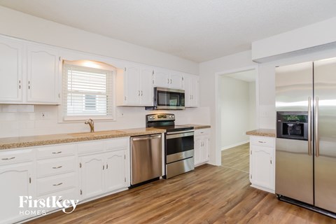 a kitchen with white cabinets and stainless steel appliances