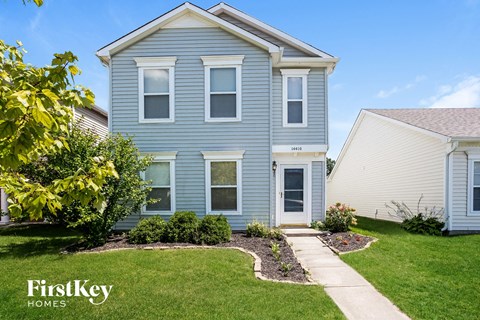 a blue house with a sidewalk in front of it