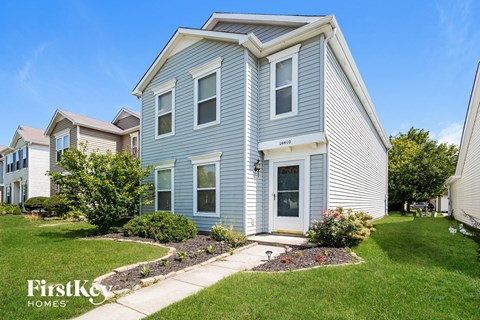 a blue house with a sidewalk in front of it