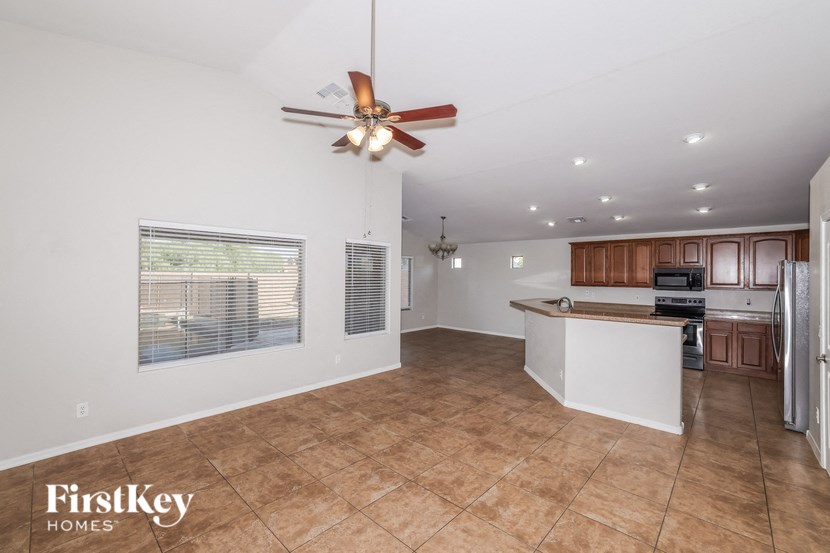an empty kitchen with a large window and a ceiling fan