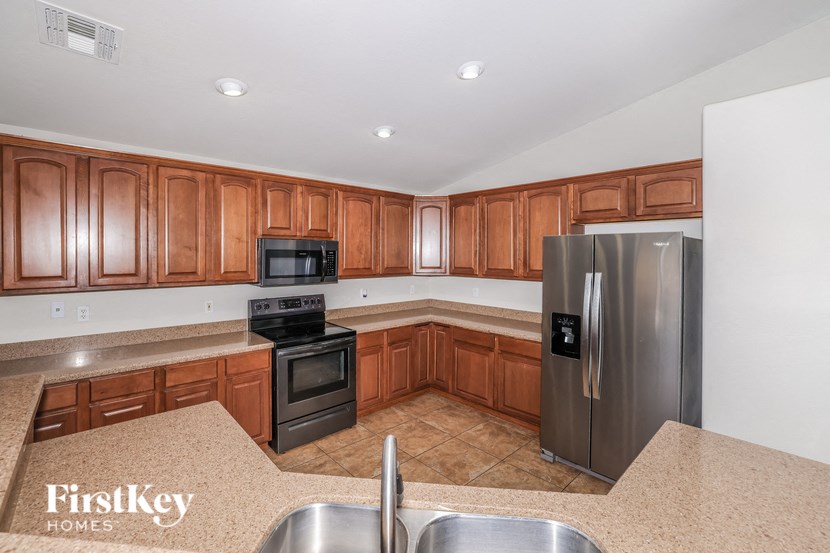 a kitchen with wooden cabinets and stainless steel appliances
