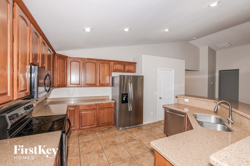 a kitchen with wooden cabinets and a stainless steel refrigerator