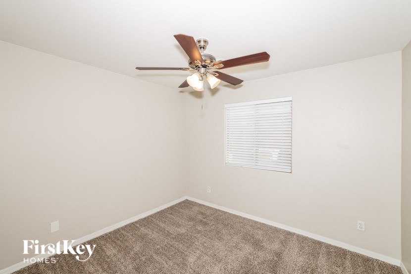 a room with a ceiling fan and a carpet