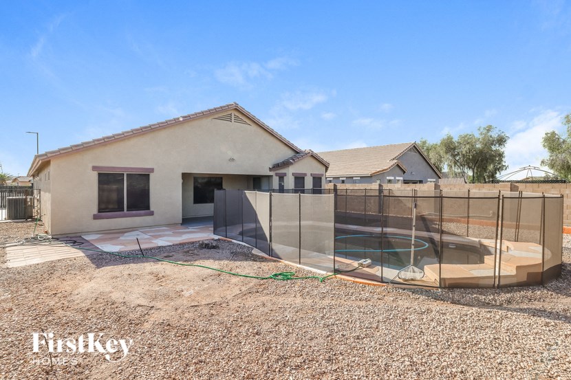 a backyard with a pool and a house with a fence