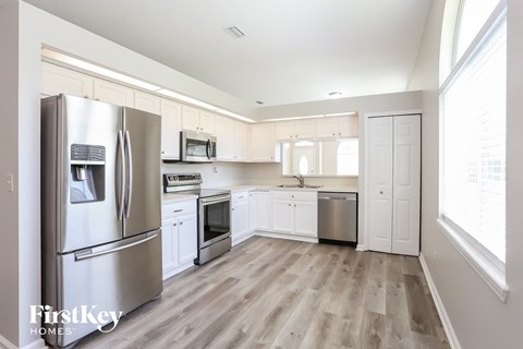 A kitchen with a refrigerator, oven, and microwave.