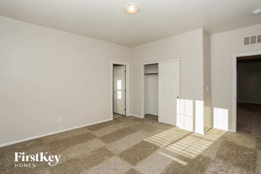 a bedroom with a door to a closet and a carpeted floor