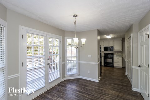 an empty living room doors and a kitchen