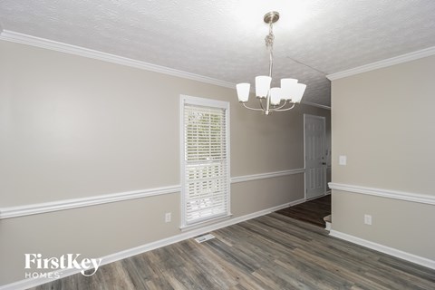 the living room of a house with a window and a chandelier