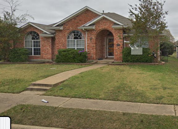 the front of a brick house with a sidewalk and grass