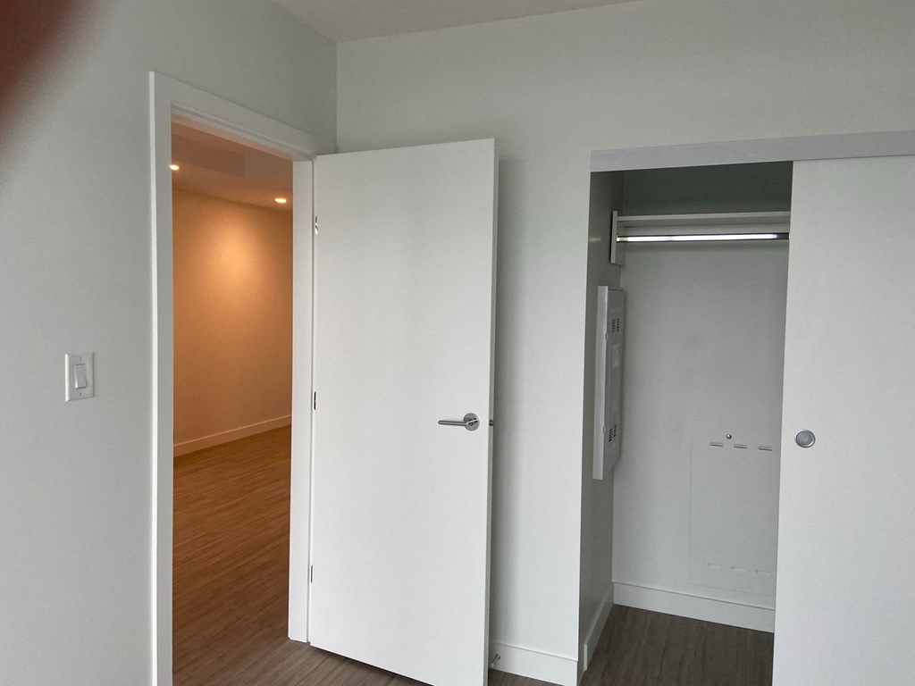 a bedroom with a closet and a door to a hallway