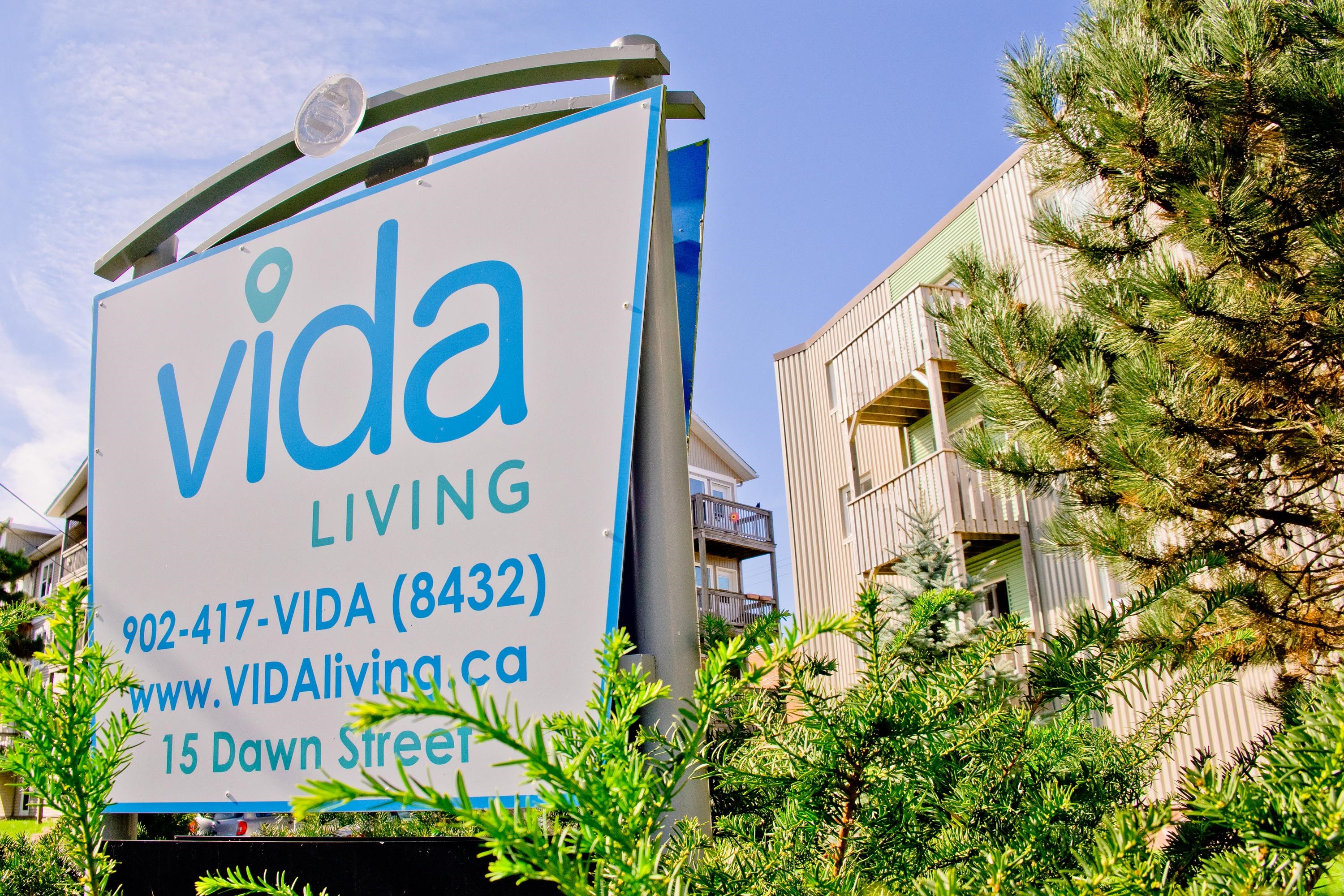 A sign for Vida Living with a phone number and website on it.