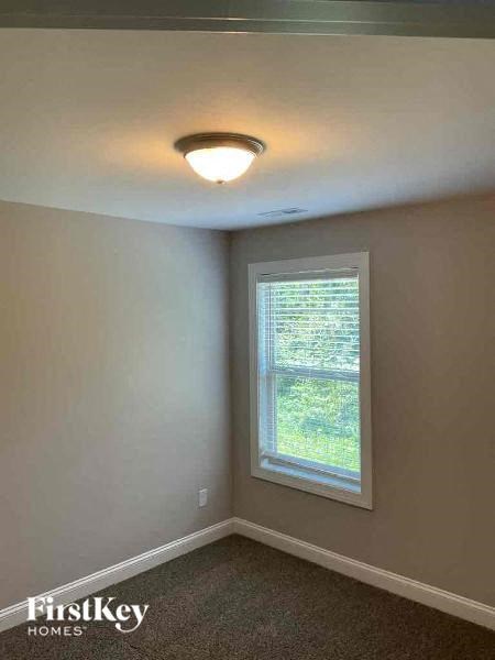 an empty room with a window and a ceiling light
