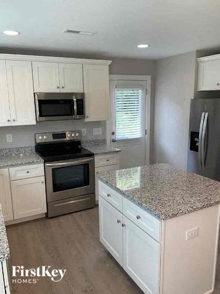 a kitchen with white cabinets and stainless steel appliances