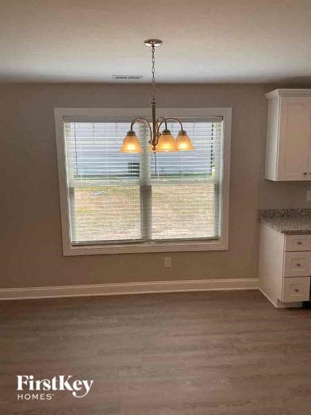 an empty kitchen with a large window and a chandelier