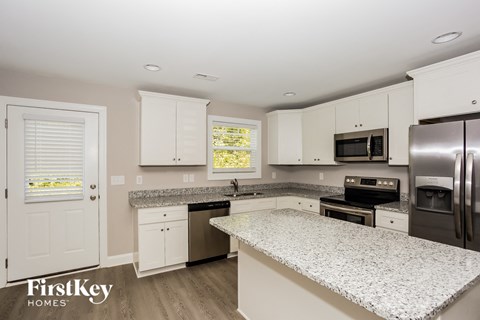 A kitchen with granite countertops and stainless steel appliances.